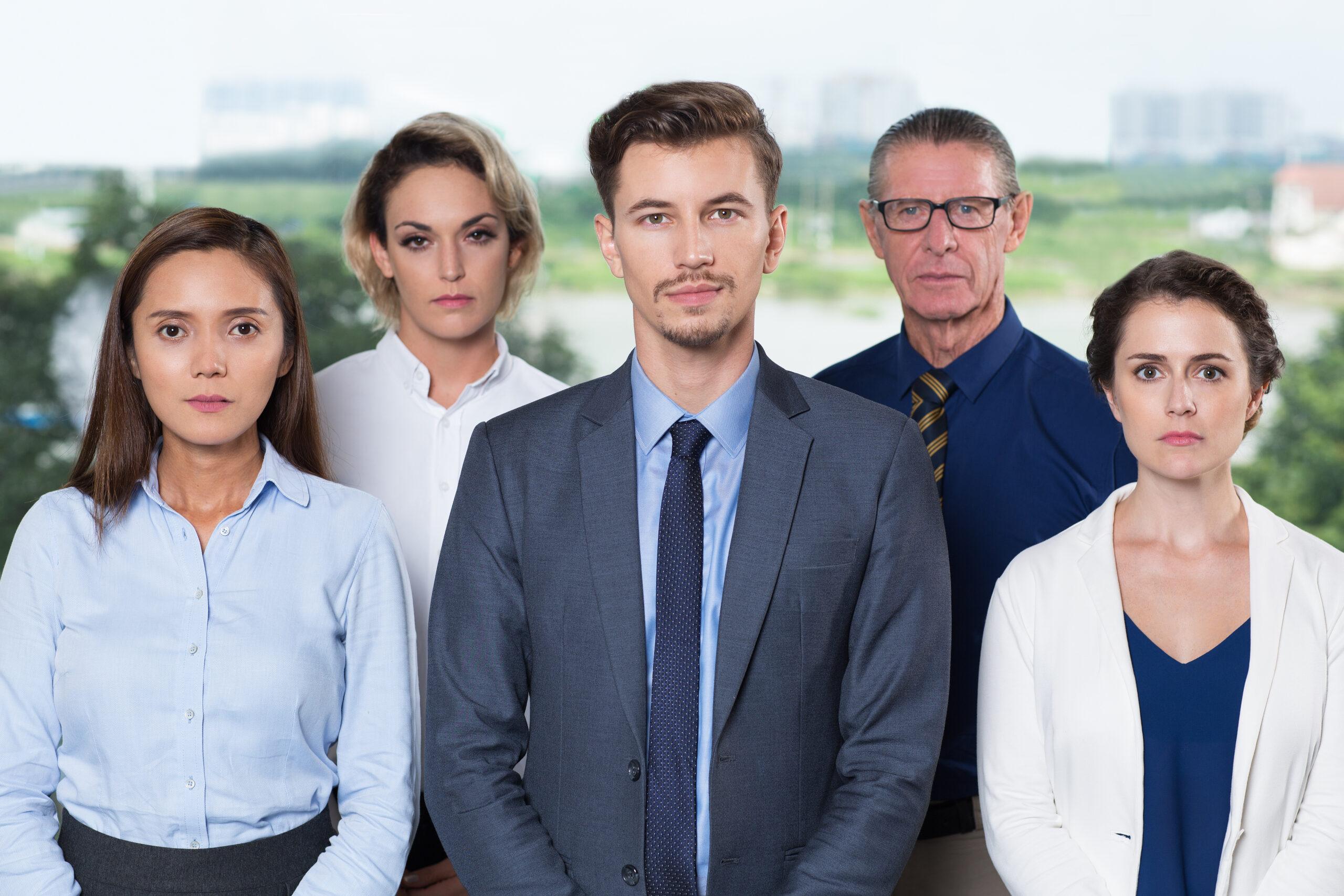 Portrait of successful business team standing in office, looking confidently at camera. Business team concept